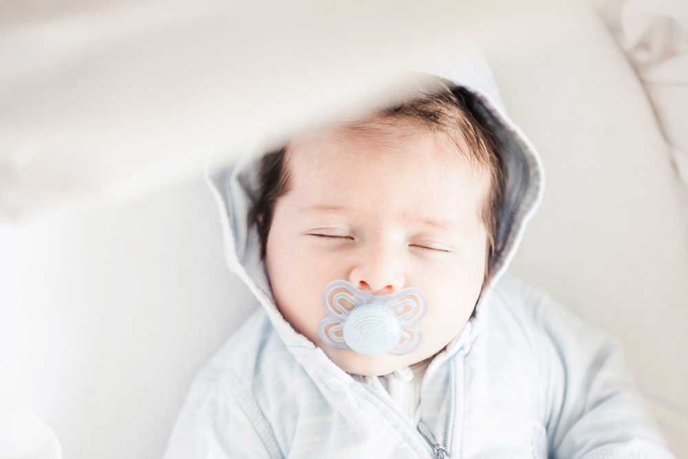 baby sound asleep with a pacifier