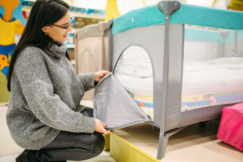 mother checking out a baby crib