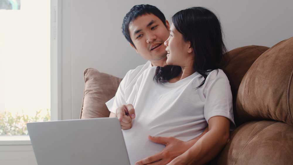 expectant parents looking at the laptop