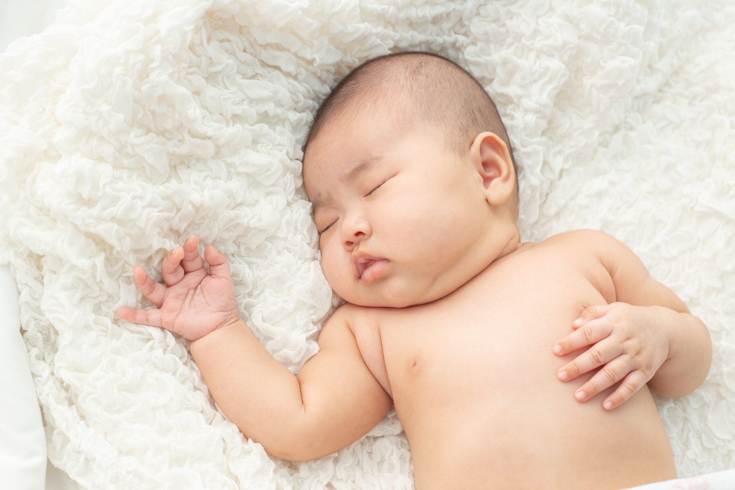 asian baby sleeping soundly on the bed