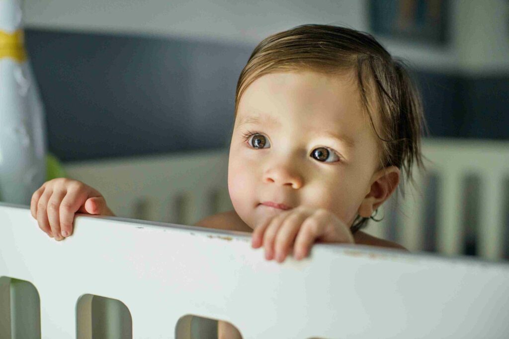 baby standing at a crib